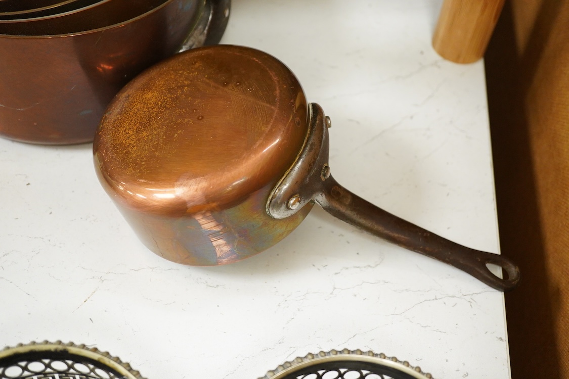A graduated set of five copper saucepans